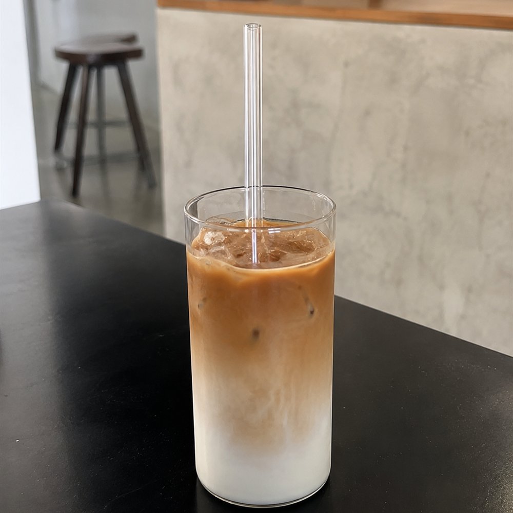 Ein Halm steht in einem hohen Glas mit Eiskaffee